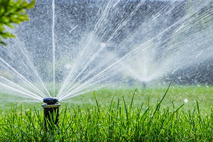 automatic sprinkler system watering the lawn on a background of green grass automatic sprinkler system watering the lawn on a background of green grass